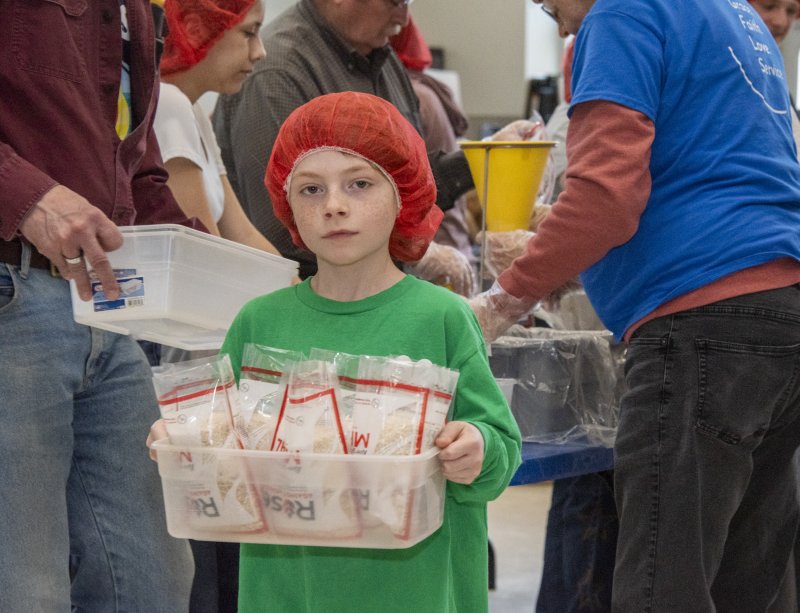 Cameron Cramer carries filled packages to the next station, where they will be weighed, sealed, labeled and packed. DENY HOWETH PHOTOS